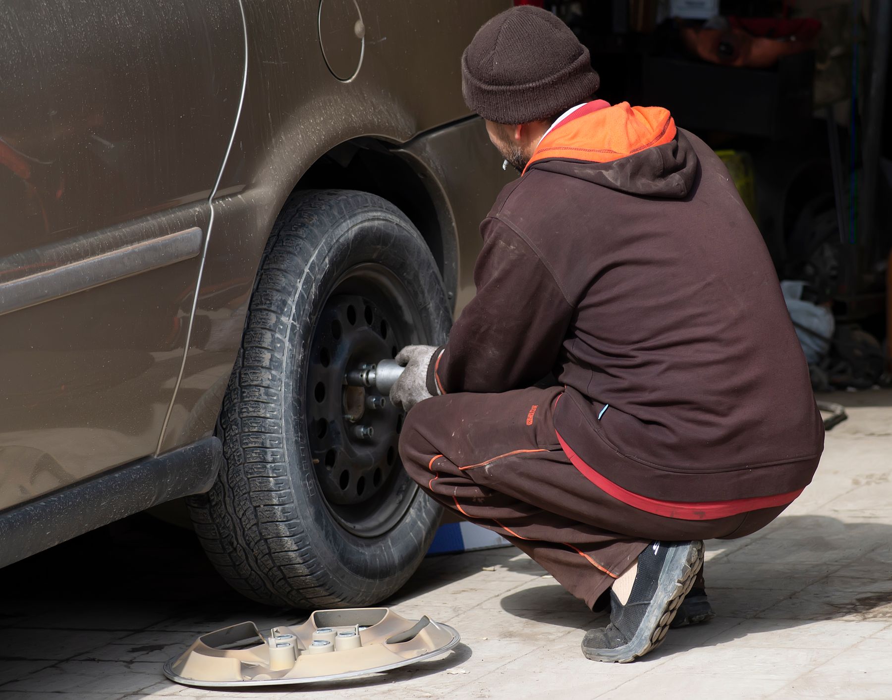 Mechanic changing a car wheel in a workshop