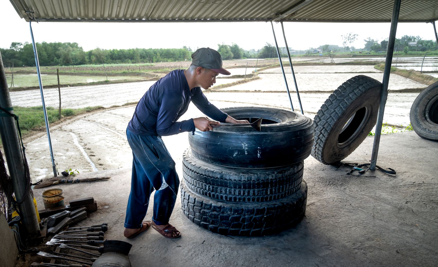 Mechanic stacking tyres in an open workshop